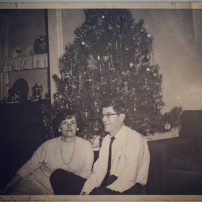 Black and white photo of Betty and Russell Williams in front of the Christmas tree.