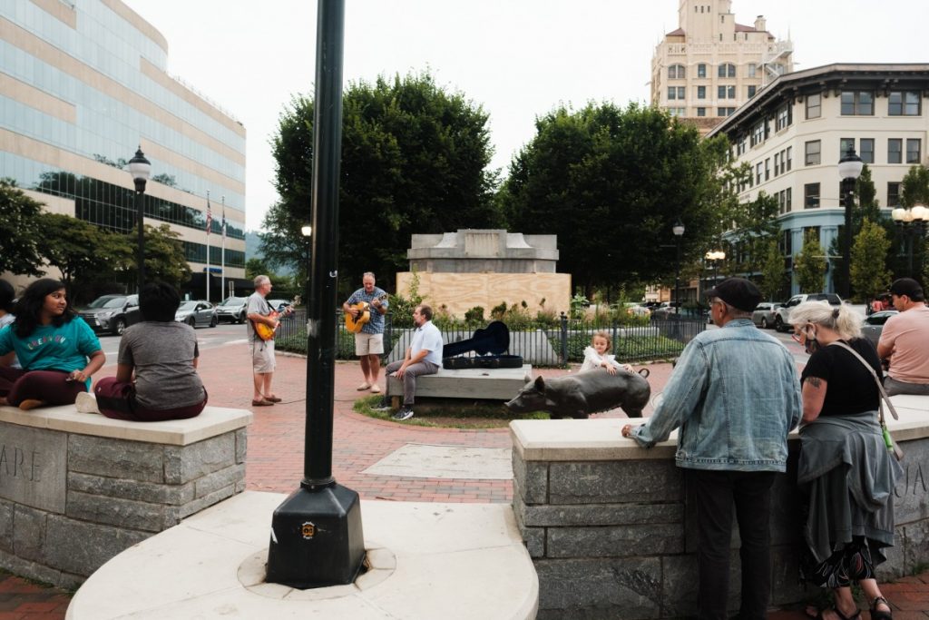 What's left of Vance Monument sits in the background of people gathered at Pack Square in Asheville, North Carolina. The obelisk that sat atop the base seen here was removed in early May. Photo: Hunter Rentz/100 Days in Appalachia